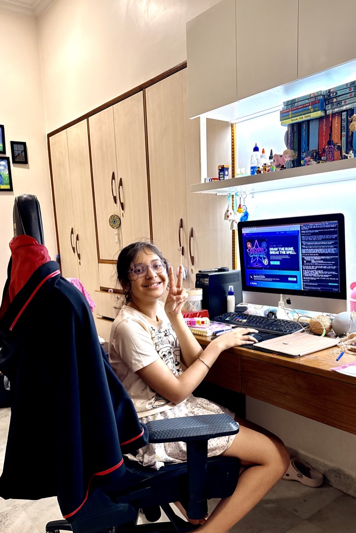 Avelyn Kaur at her desk with Glyph Caster running on the monitor